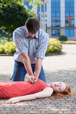 Man preforming CPR on woman